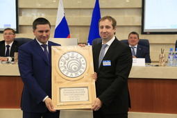 Дмитрий Кобылкин вручает Алексею Давыдову памятный знак "Первая скважина"